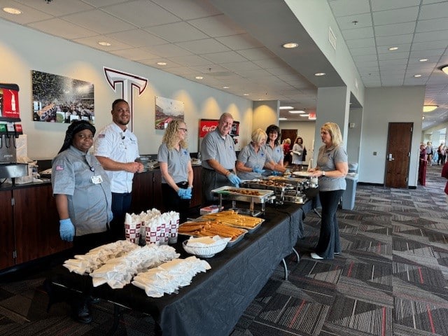 a group of people standing around a table