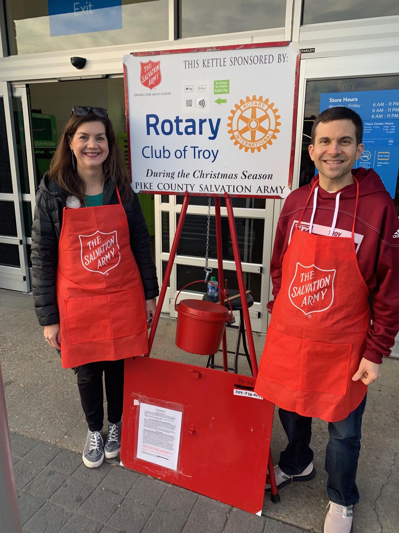 a man and a woman standing in front of a sign