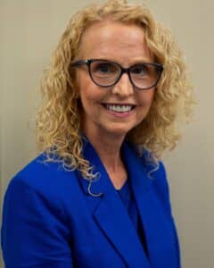 a woman wearing glasses and a blue shirt