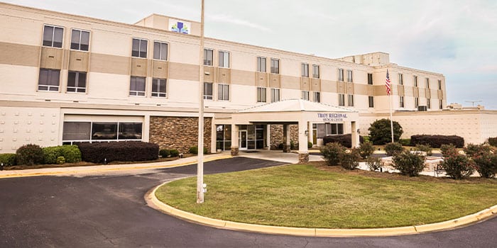 Hospital exterior with main entrance and landscaped surroundings.