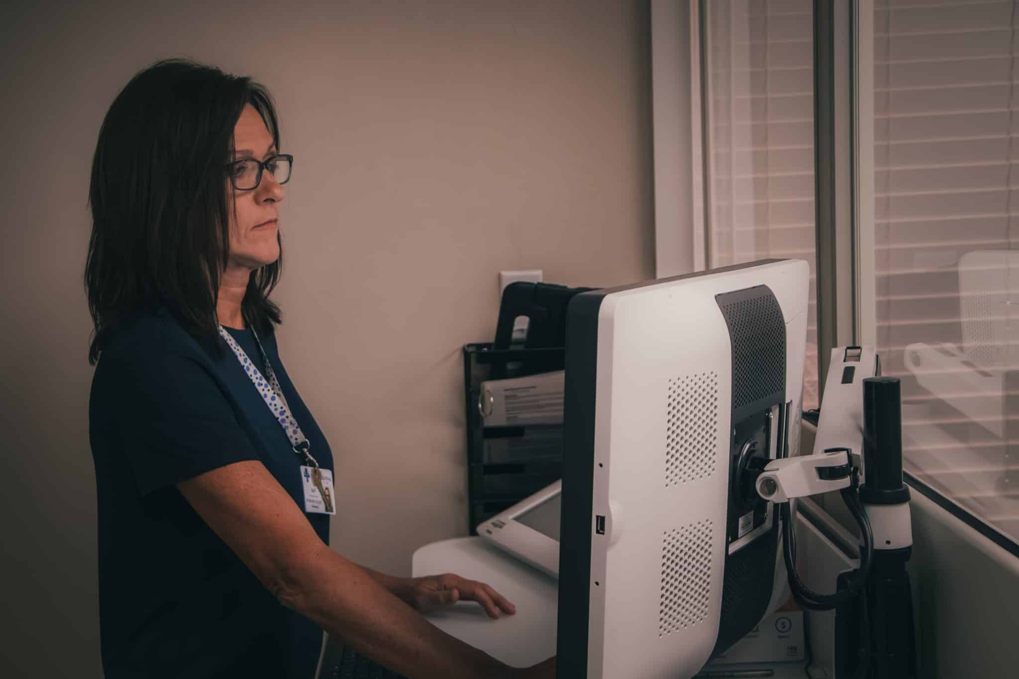 A woman working at a computer in an office setting.