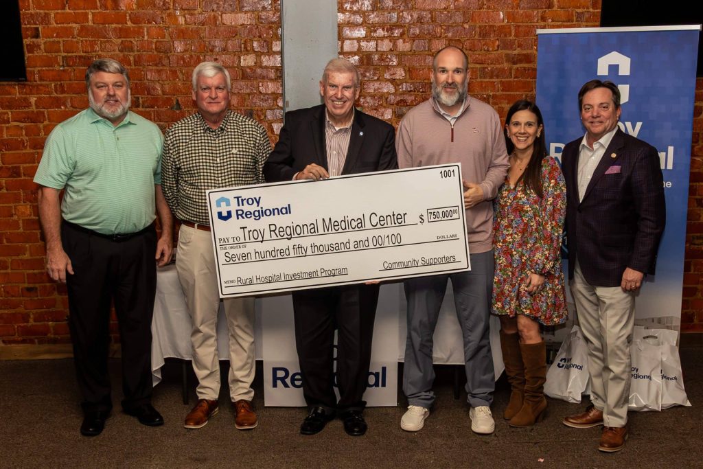Group holding a large donation check for Troy Regional Medical Center.