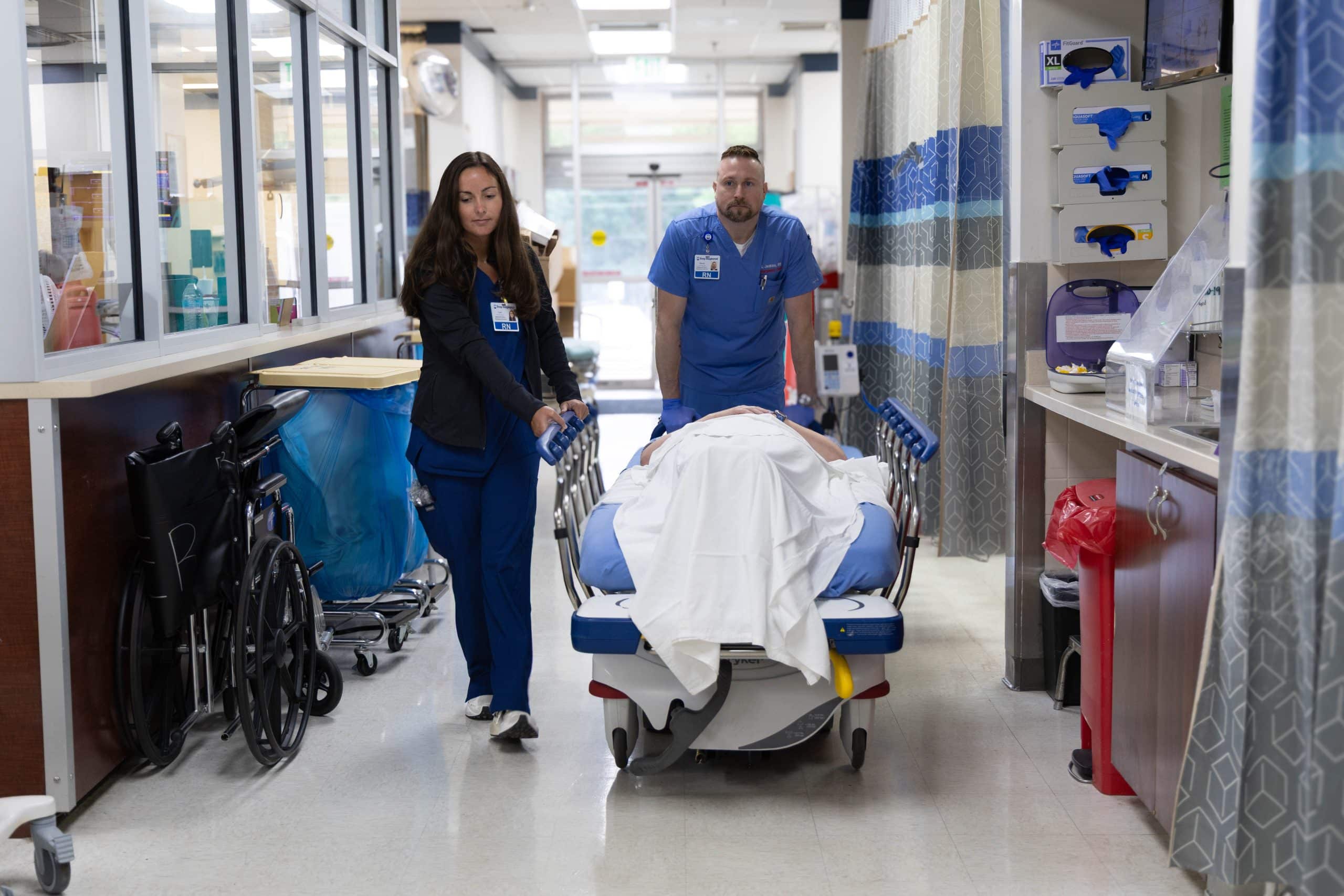 Healthcare workers transporting a patient on a hospital gurney.