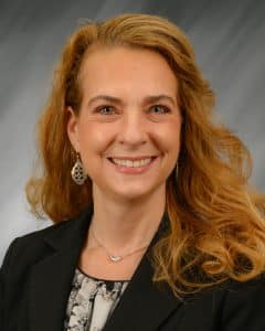 Troy University A woman with curly blond hair smiling in a professional portrait.