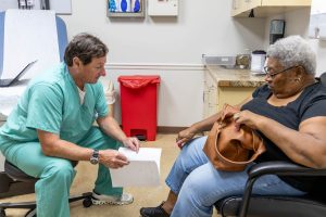 Healthcare professional consulting with a patient in a doctor's office.
